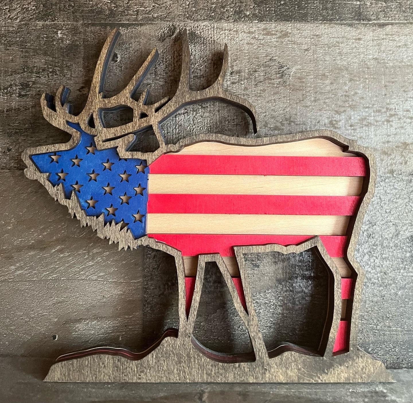 Handmade wooden elk sculpture with USA flag design, unique gift from Bunkhouse Studio LLC, detailed craftsmanship and patriotic theme.