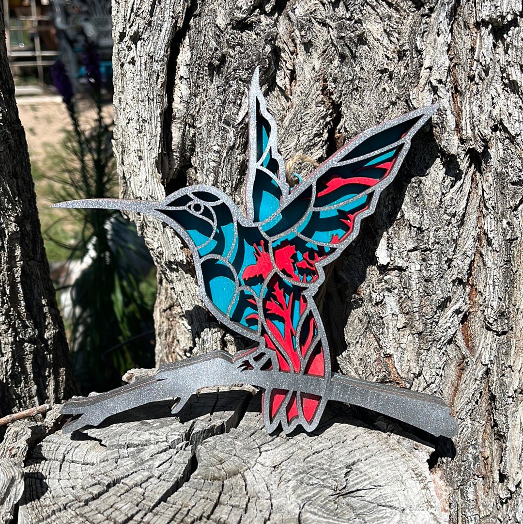 Colorful hummingbird sculpture by Bunkhouse Studio LLC, detailed metal art piece showcasing vibrant feathers and delicate wings.