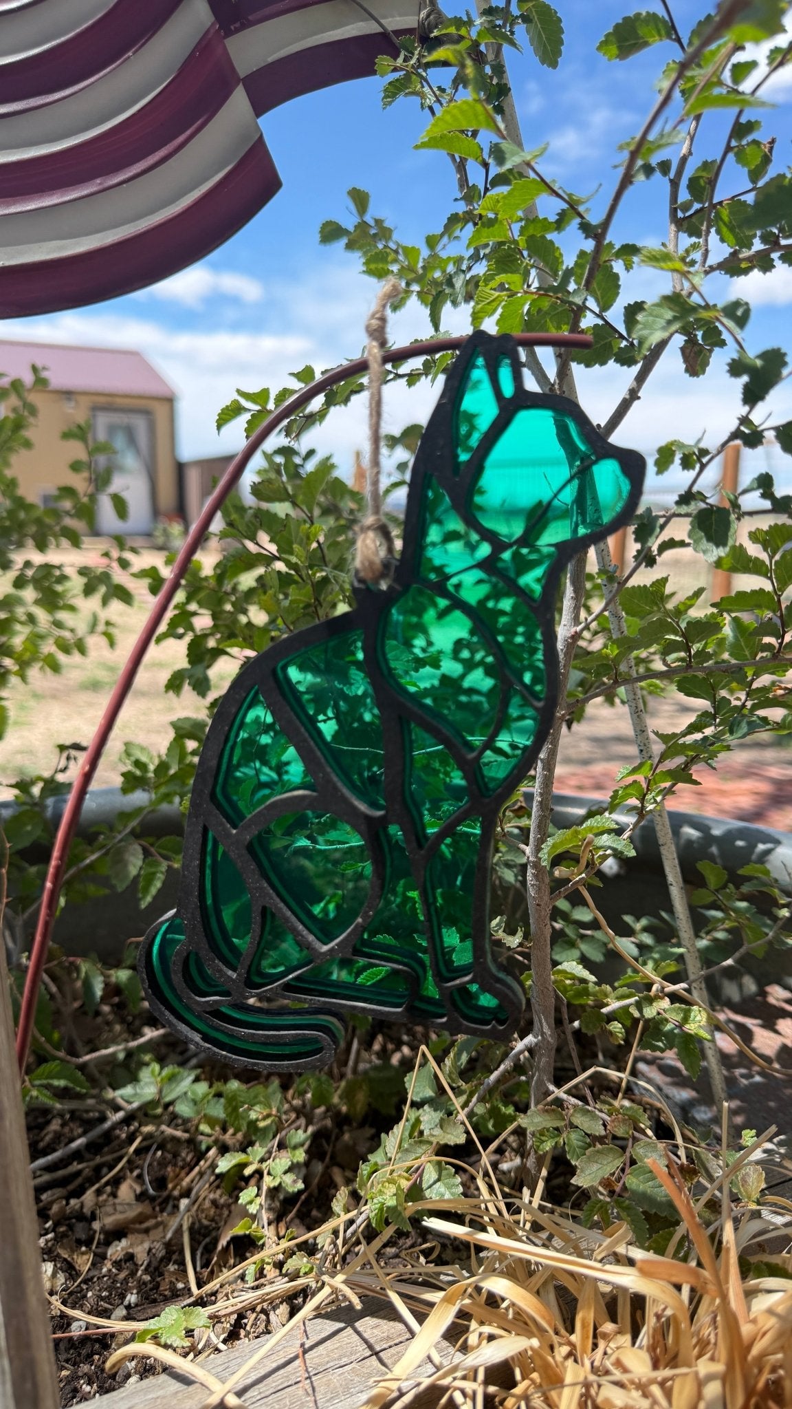 Rustic modern cat lover sun catcher window decor by Bunkhouse Studio LLC hanging in a sunny window.