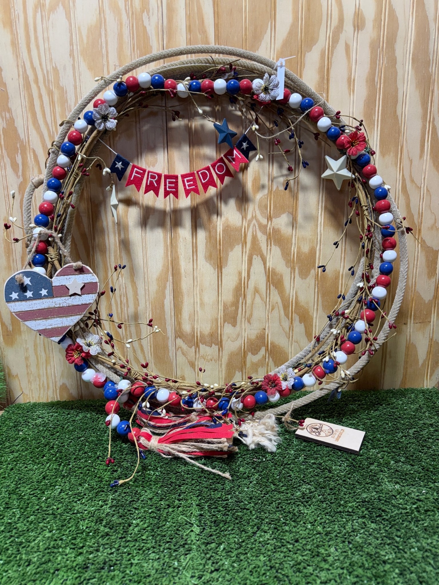 Decorative rope wreath by Bunkhouse Studio LLC featuring a natural, rustic design with intertwined rope and a circular shape.