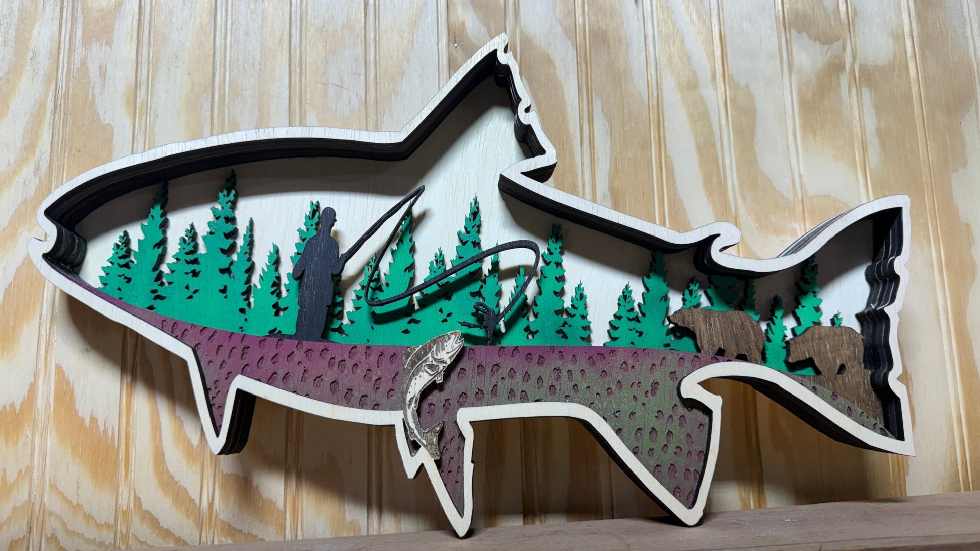 Handcrafted wooden trout wall art by Bunkhouse Studio featuring a fly fisherman scene, perfect rustic cabin or lodge decor.