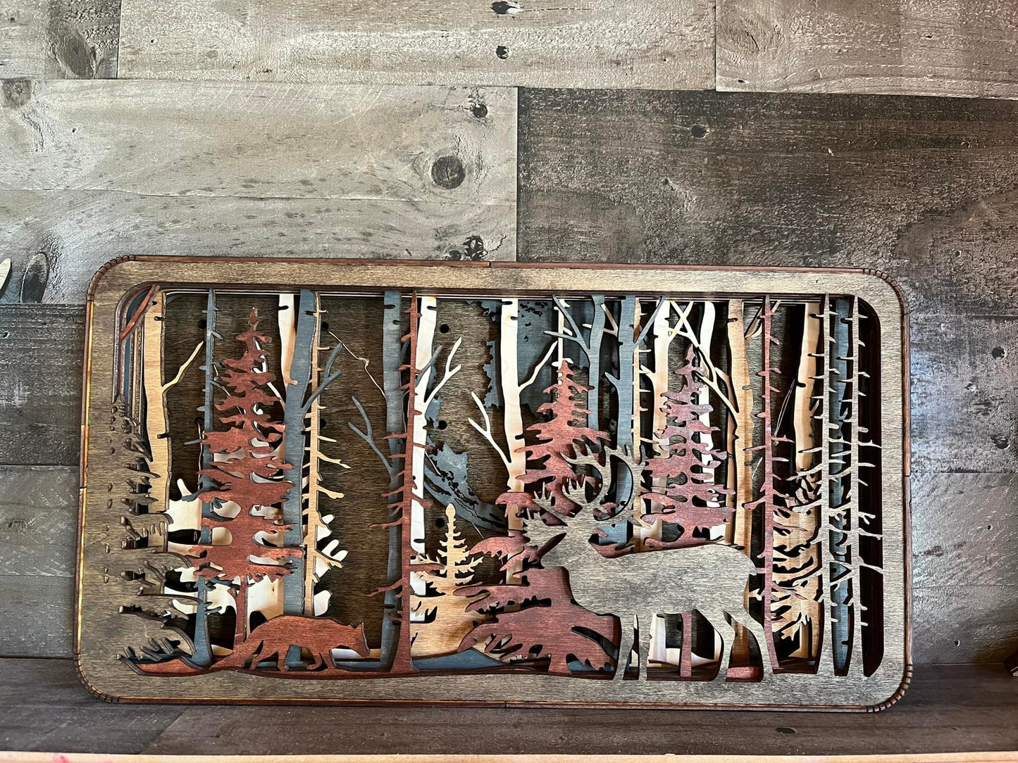 Layered Caribou Light Shadow Box by Bunkhouse Studio LLC showing a detailed wooden caribou silhouette with backlit design.
