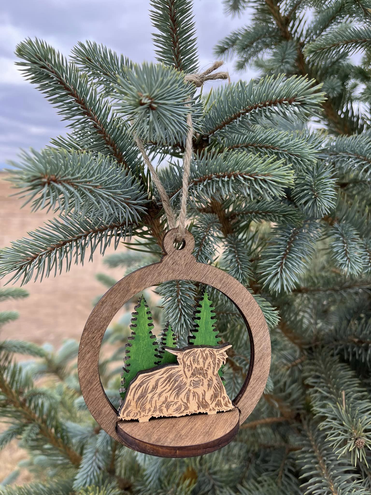 Two-layer circular ornament by Bunkhouse Studio LLC featuring intricate cut-out designs and a natural wood finish.