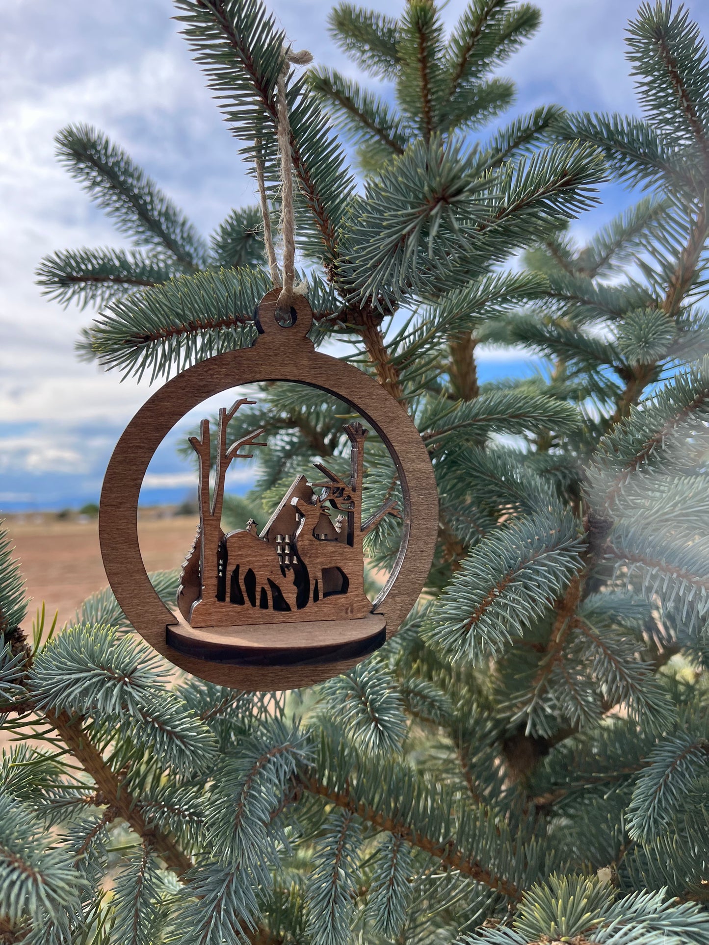 Two-layer circular ornament with intricate cutout design by Bunkhouse Studio LLC, showcasing detailed craftsmanship and artistic style.