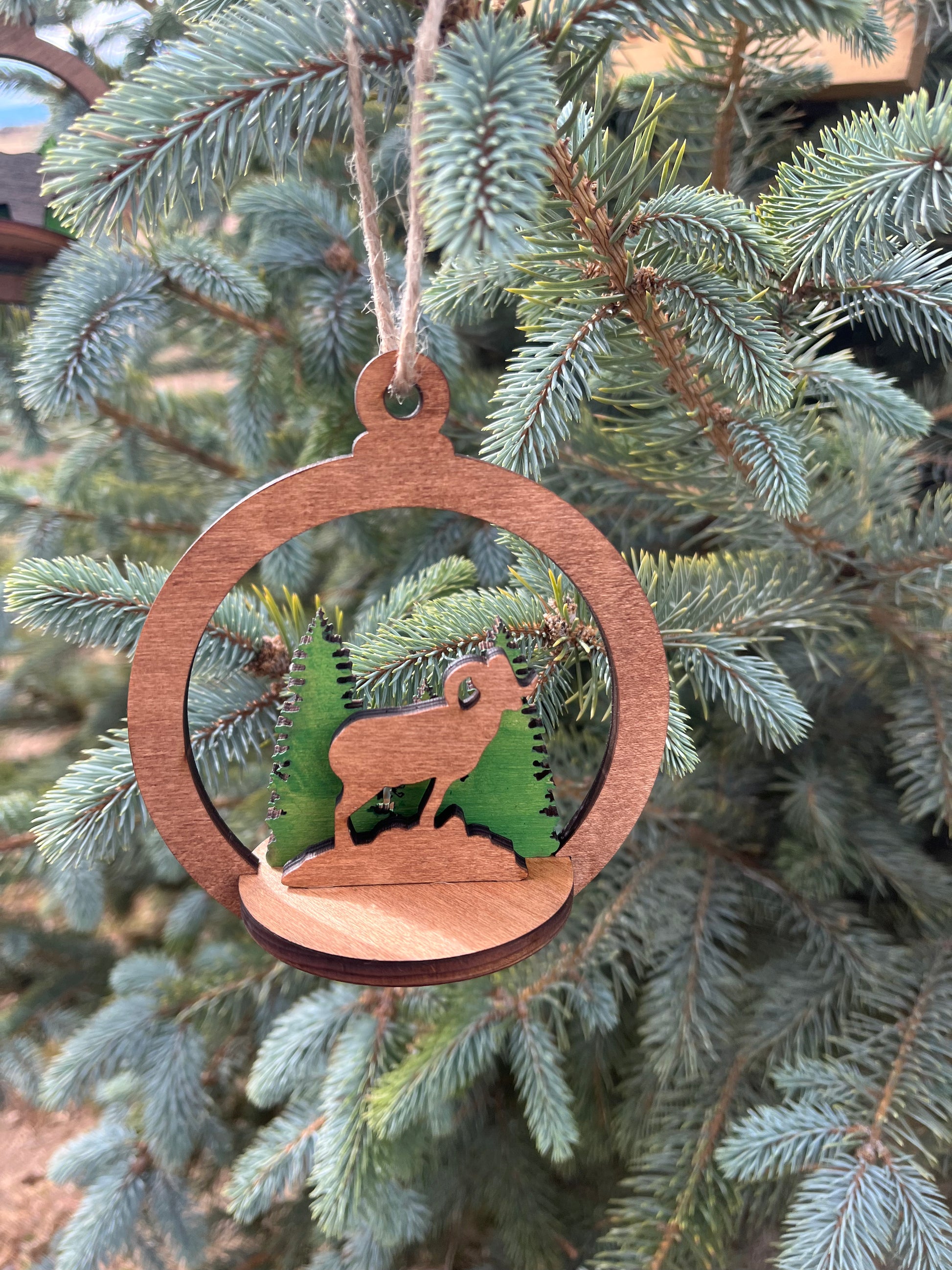Two-layer circle ornament by Bunkhouse Studio LLC featuring a wooden and decorative design with intricate cutouts.