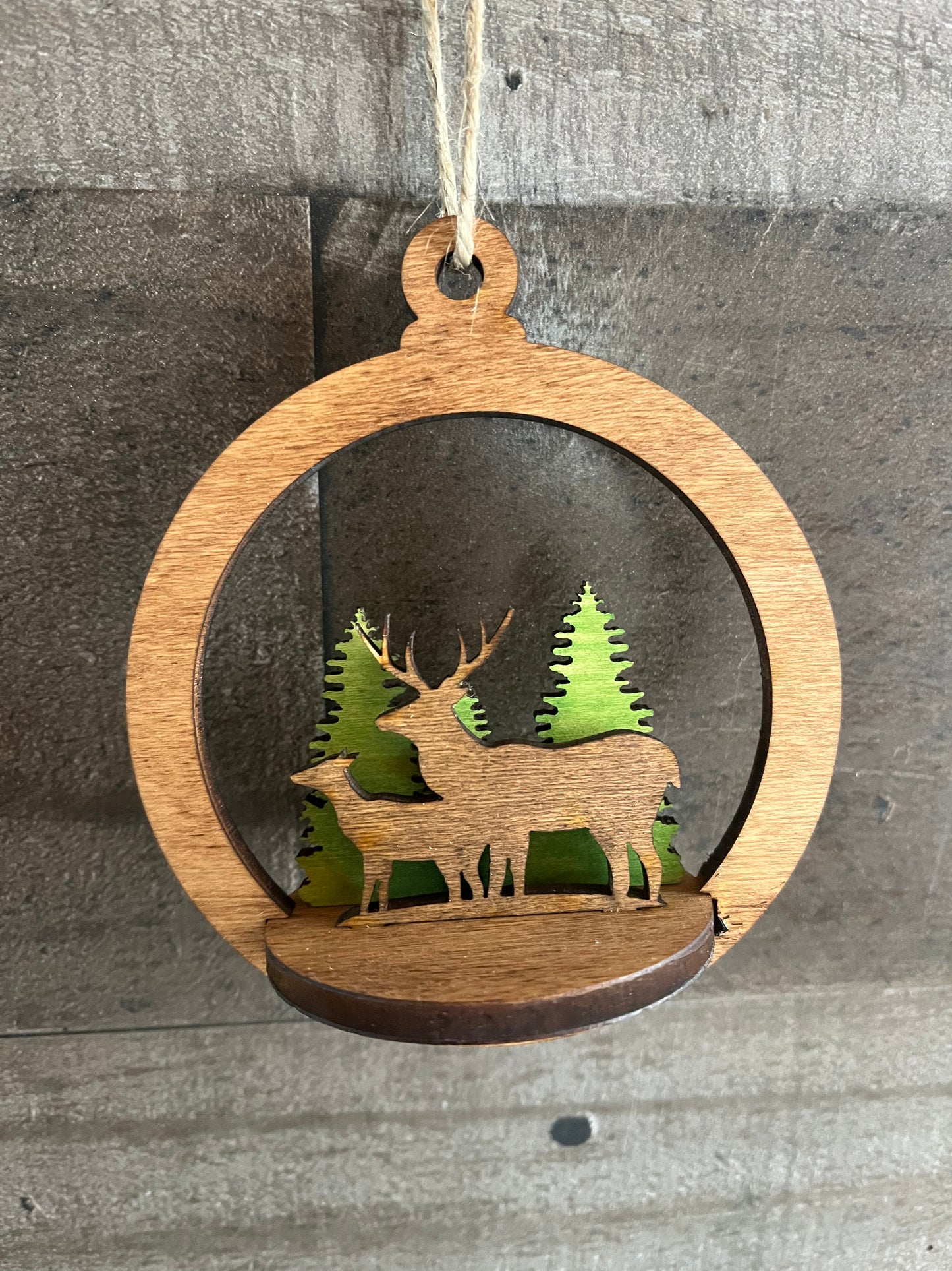 Two-layer circular ornament by Bunkhouse Studio LLC featuring intricate cut-out designs and a natural wood finish.