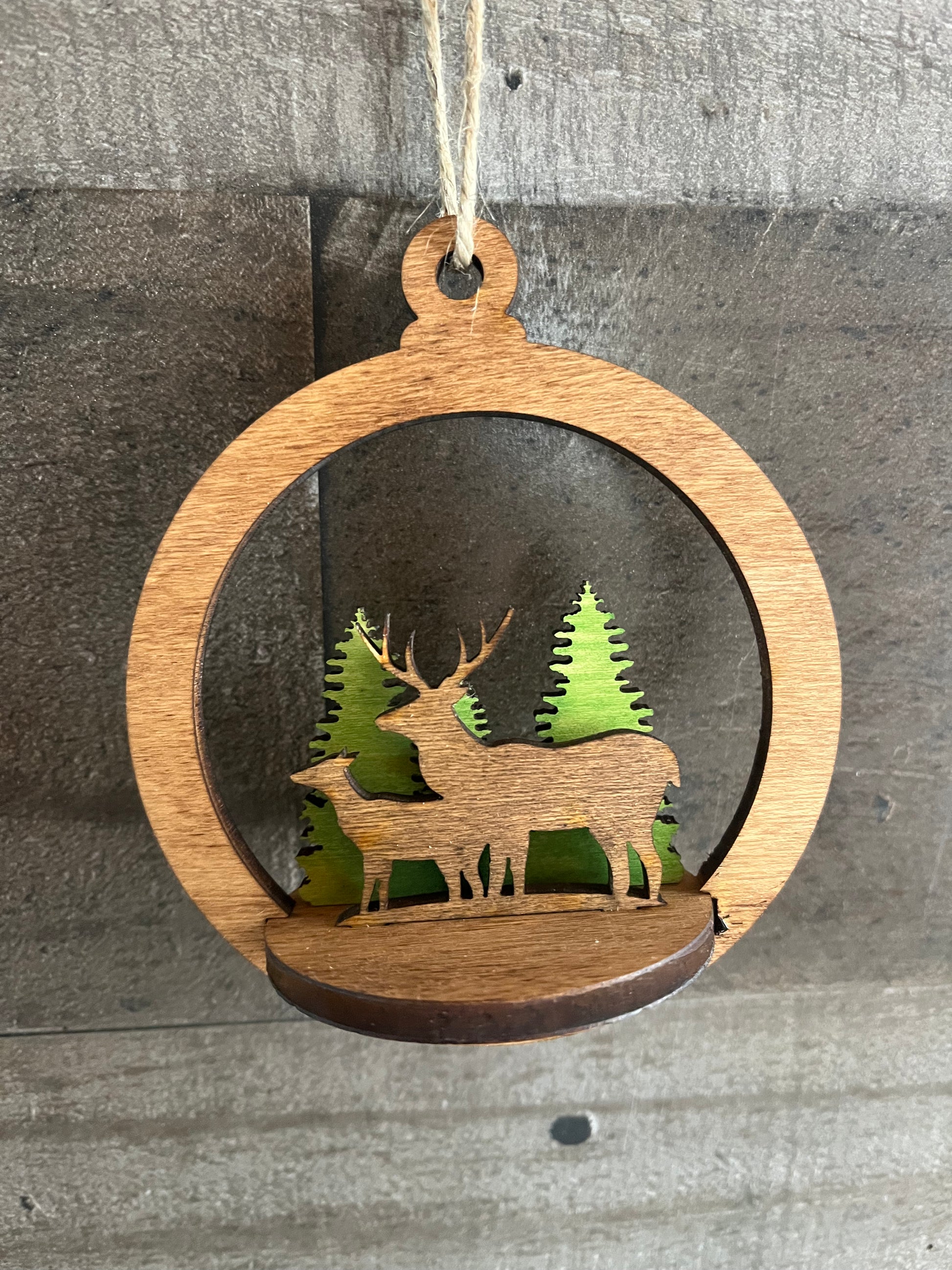 Two-layer circular ornament by Bunkhouse Studio LLC featuring intricate cut-out designs and a natural wood finish.